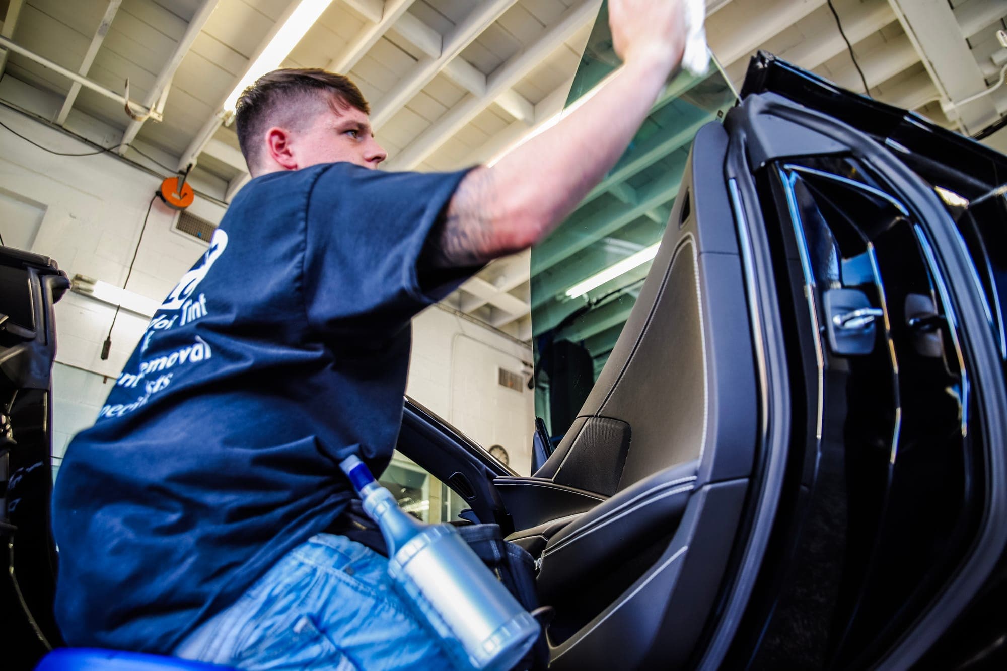 A technician smoothing film onto a window